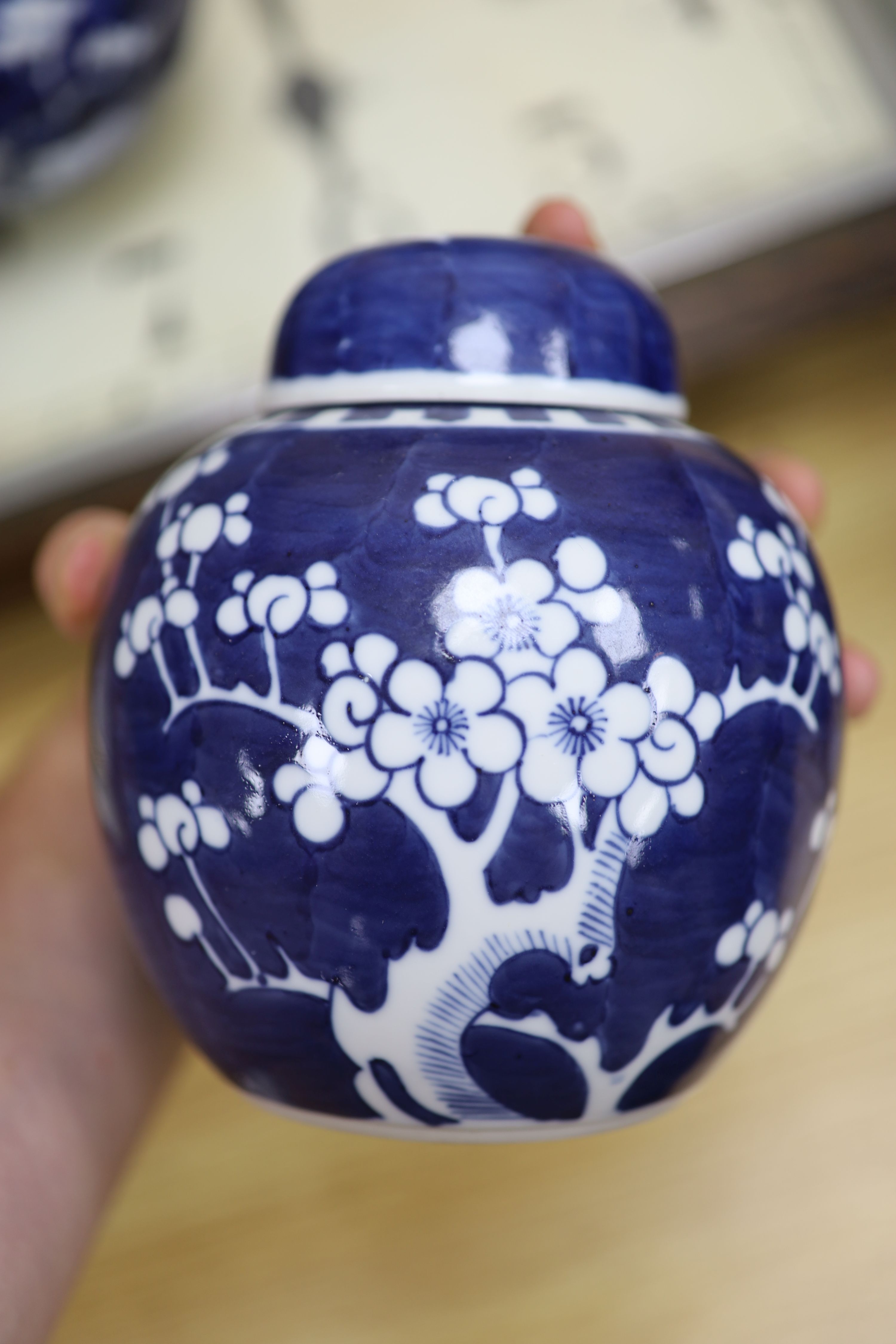 Two Chinese blue and white prunus pattern ginger jars and a similar cylinder vase, tallest 26cm